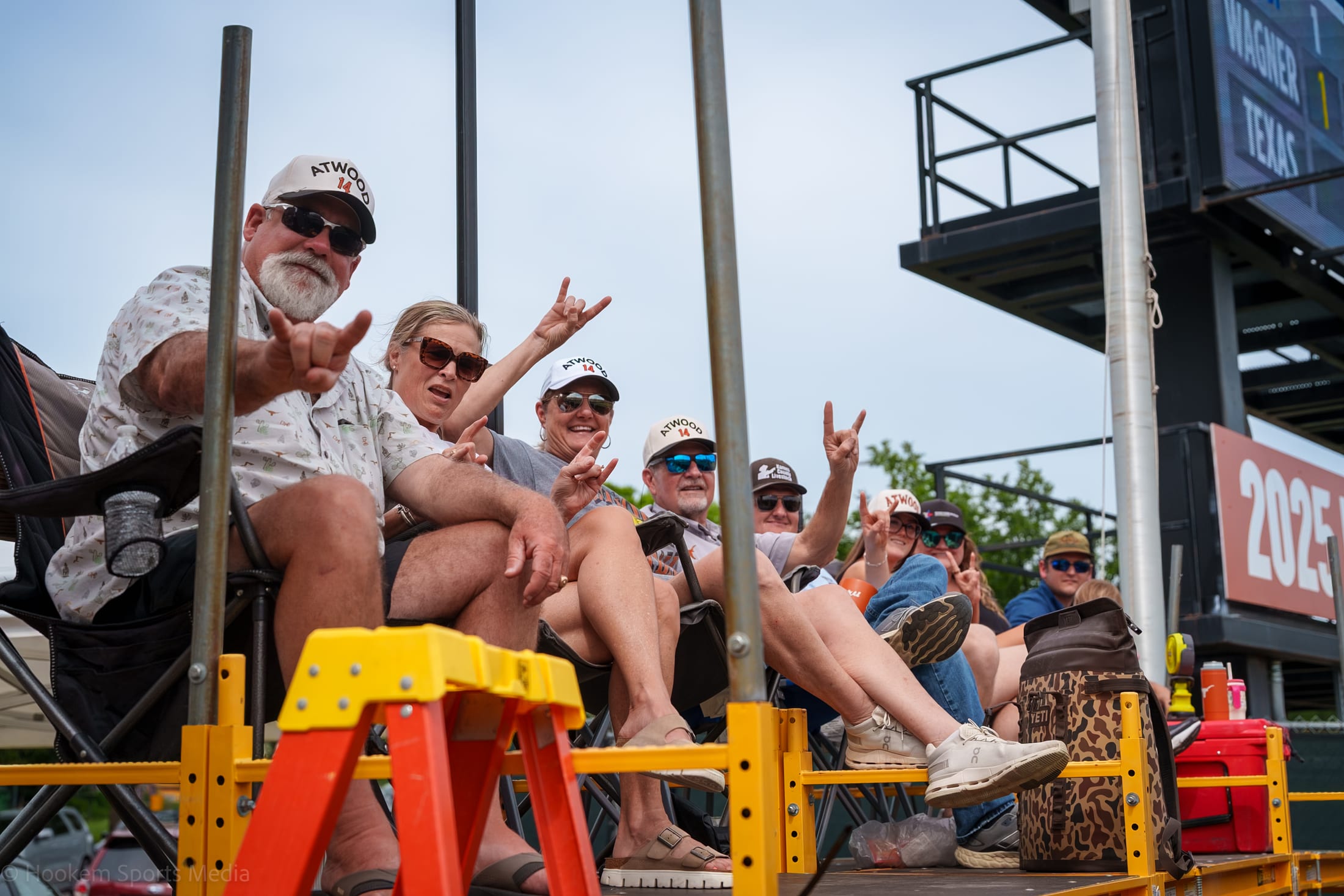 The Atwood family watch a Texas Longhorn Softball game from a family constructed scaffold.