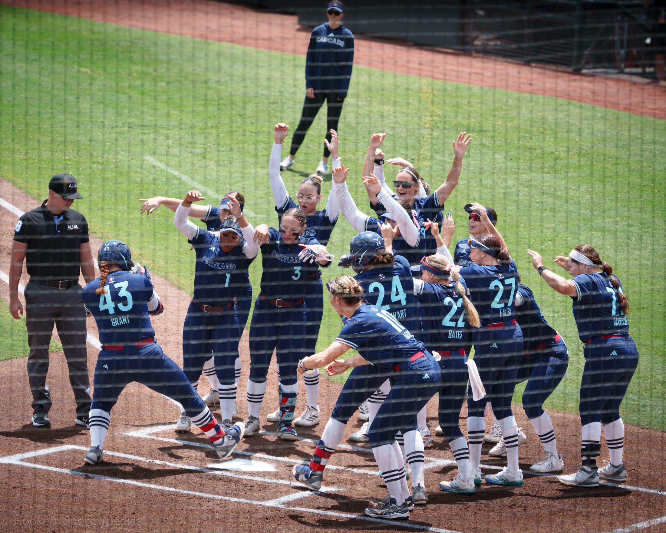 Megan Grant is greeted at home plate by the Portland Cascade after a home run at Dell Diamond.