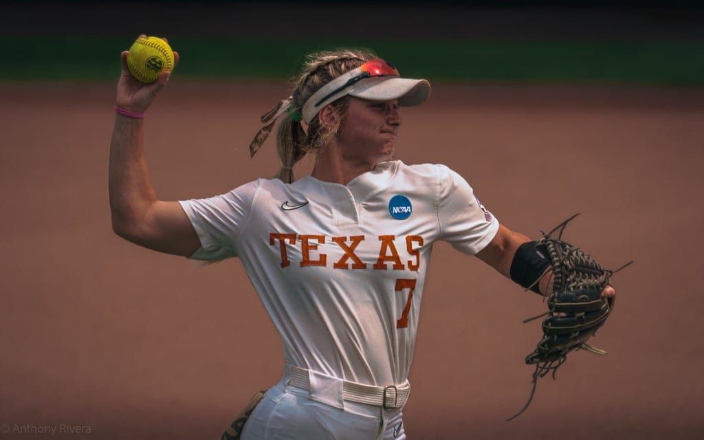 Ashton Maloney in her Texas uniform with glove at her chest.
